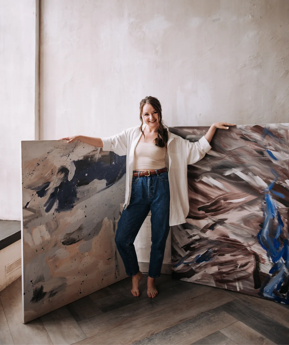 Lena smiling between two large abstract paintings