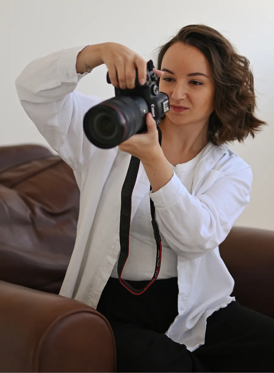 Lena raising her camera to take a photograph